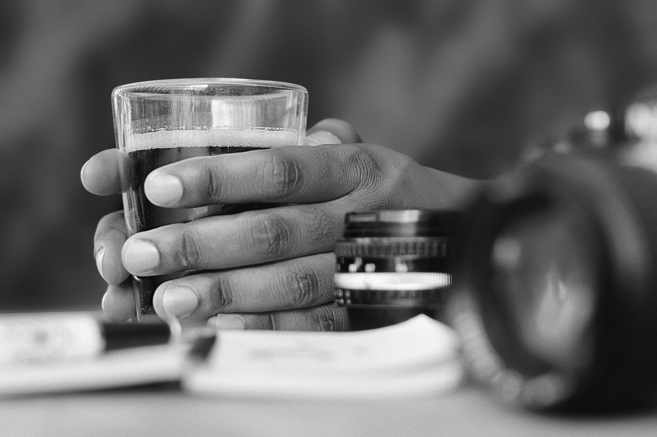 En Sie ein Bild, das eine Nahaufnahme der Hand eines Fotografen zeigt, der ein Farbkalibrierungstool auf einem Computermonitor akribisch anpasst und so die Bedeutung einer präzisen Farbdarstellung für Fotografen hervorhebt