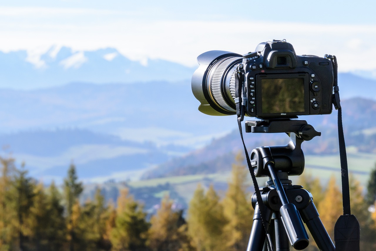 En Sie ein Bild, das einen Fotografen zeigt, der die Farbtemperatureinstellungen einer Kamera anpasst, mit einer lebendigen, warm getönten Sonnenaufgangslandschaft im Hintergrund und einer kühlen, blauen Stundenstadtlandschaft im Vordergrund