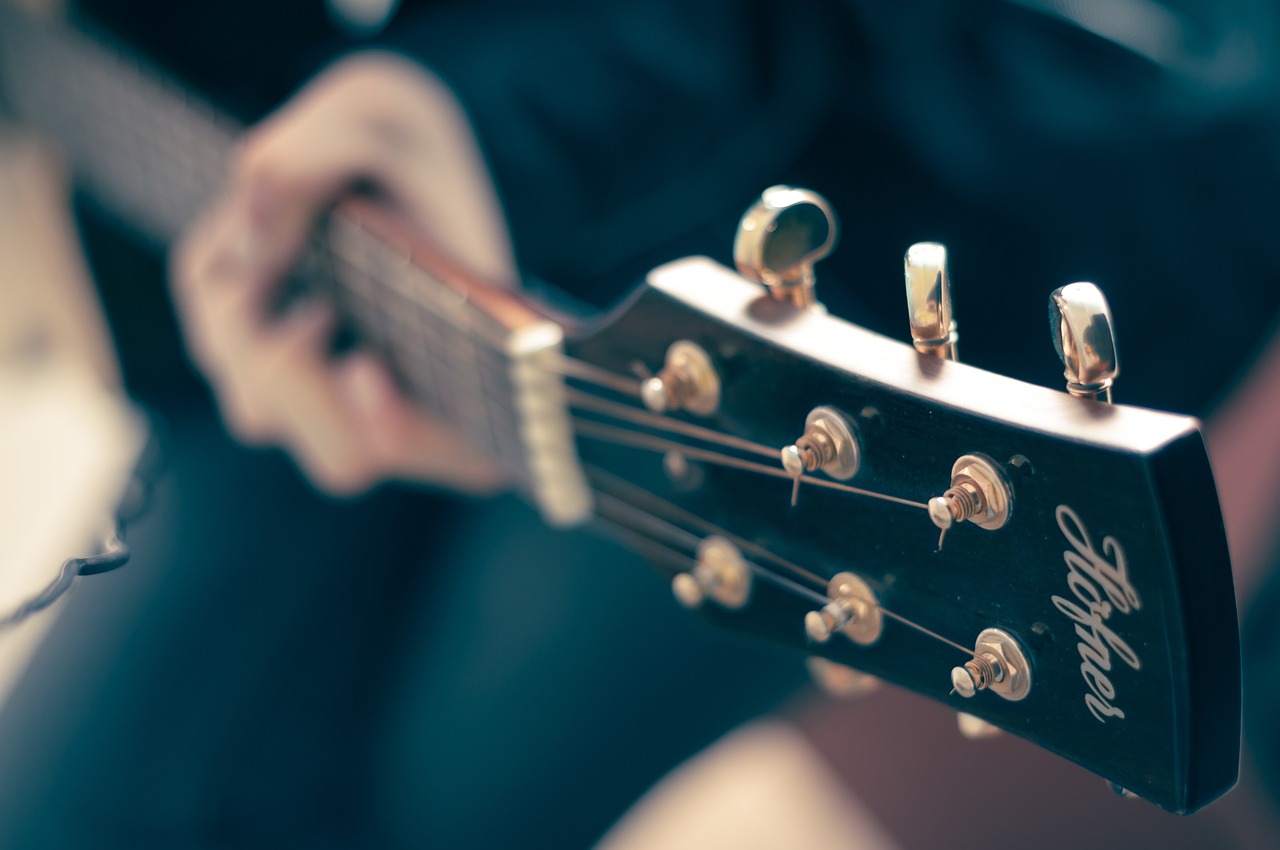 En Sie ein Bild, das einen Musiker in einem Studio zeigt, umgeben von einer Vielzahl farbenfroher Instrumente und Geräte
